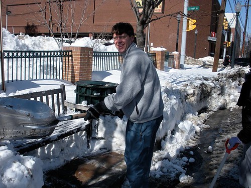 Hans Riemer clearing out a bus stop on Fenton near Thayer, downtown Silver Spring.  Subsequent bus riders stood in the clearing, with bags placed on the bench.